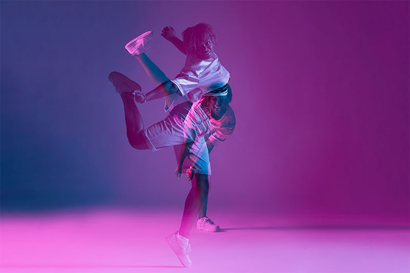 Dubbele belichtingsfoto van danseres met explosieve moves in de kleuren magenta, paars en blauw